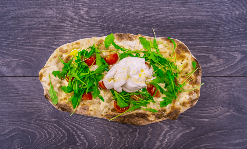 Pinsa Capri with Burrata cheese rocket salad and cherry Tomatoes